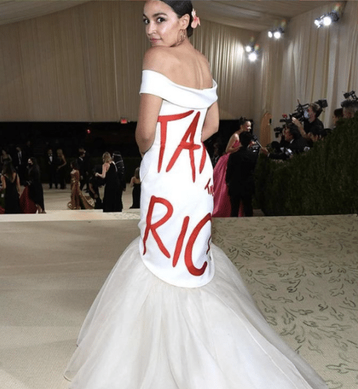 AOC wearing a white gown with “Tax the Rich” written in red across the back at the Met Gala.