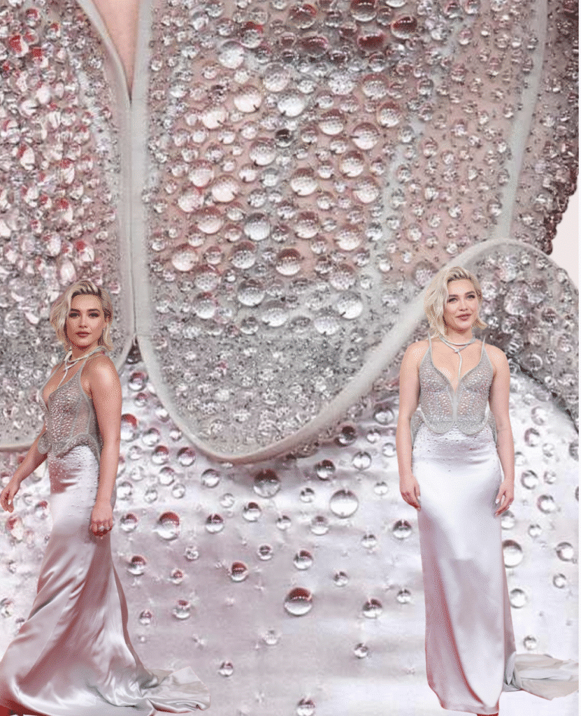 Woman wearing a silver crystal-embellished bodice paired with a silky white satin skirt, walking confidently on the red carpet.