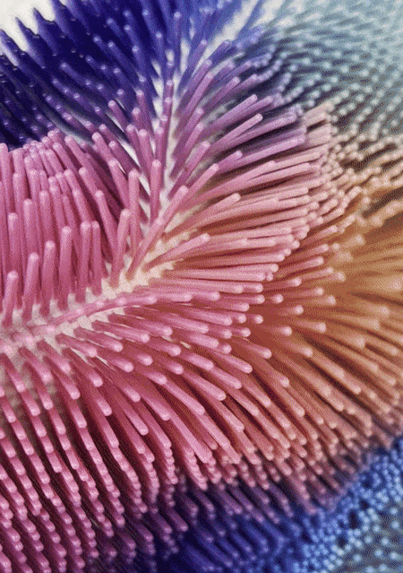 Animated surface of flexible, colorful spikes rippling in waves, creating a dynamic kinetic textile effect.
